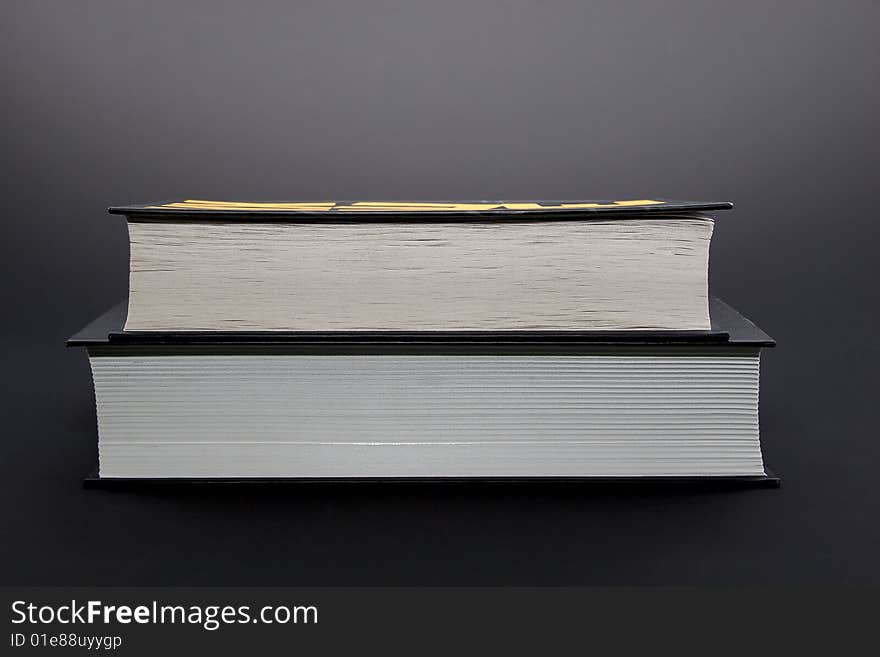 Two thick black books isolated on black background. Two thick black books isolated on black background