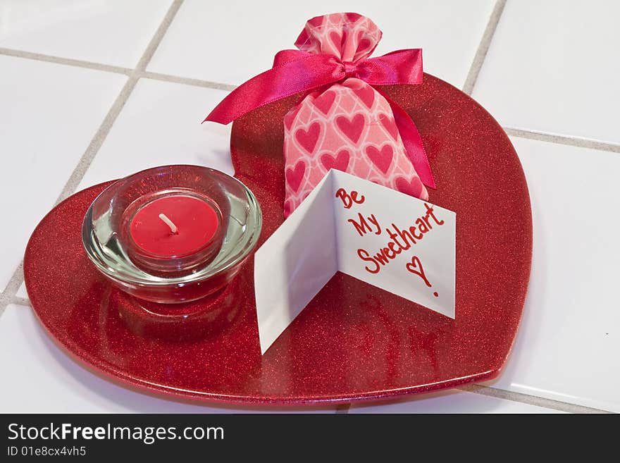 Red metallic heart dish with red candle in holder and valentine sachet with card. Red metallic heart dish with red candle in holder and valentine sachet with card