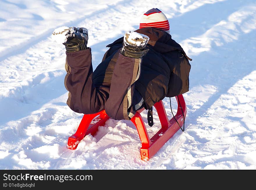 The boy of ten years old, slides on the sleighs. The boy of ten years old, slides on the sleighs