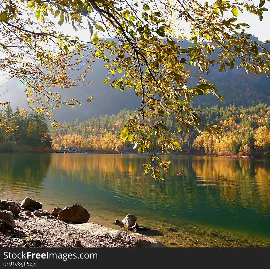 Autumn's natural beauty is reflected in a calm lake on a bright and sunny fall day. Autumn's natural beauty is reflected in a calm lake on a bright and sunny fall day.