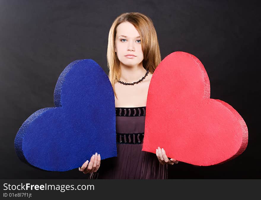 Pretty girl portrait with two hearts  over black background