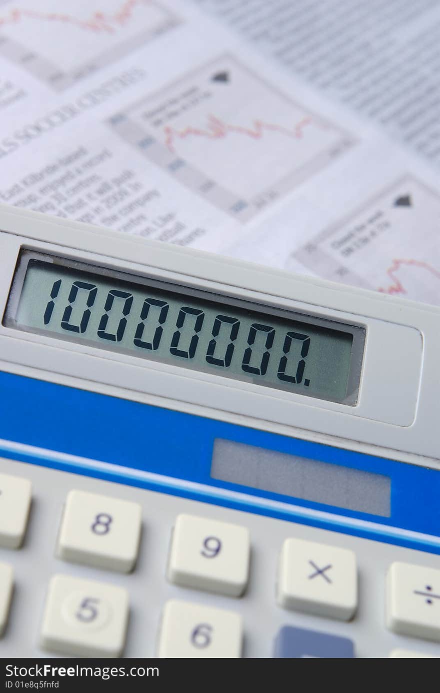 Calculator with financial newspaper in background. Selective focus.