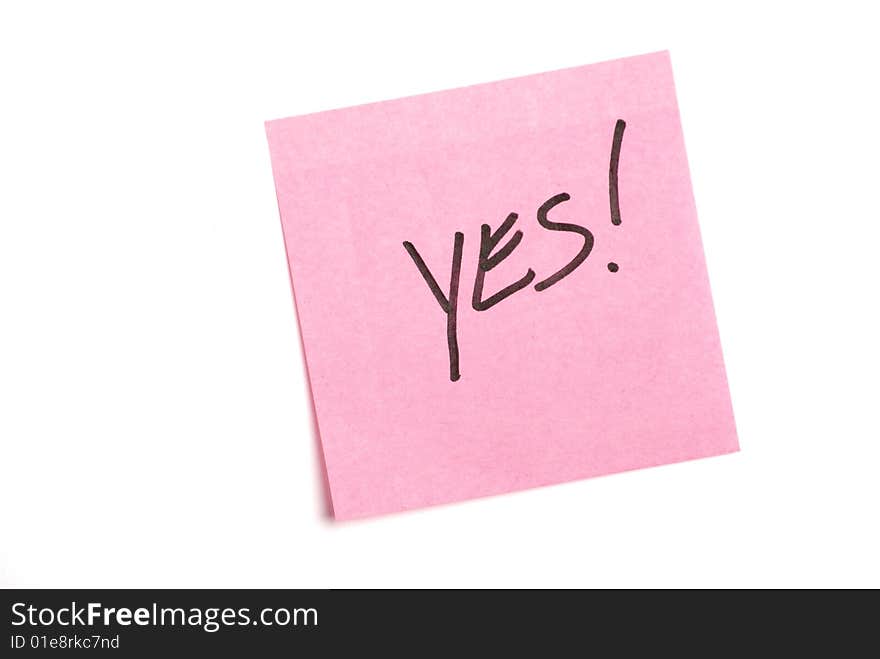 Pink post it note isolated on white with yes written.