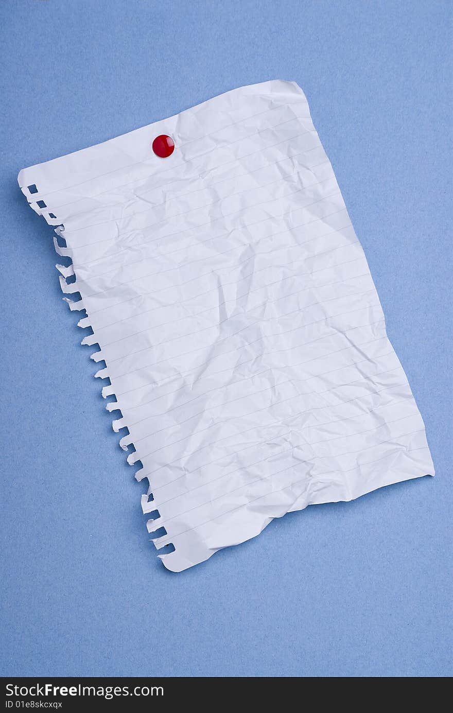 Blank spiral-bound notepaper page crumpled on blue background. Blank spiral-bound notepaper page crumpled on blue background