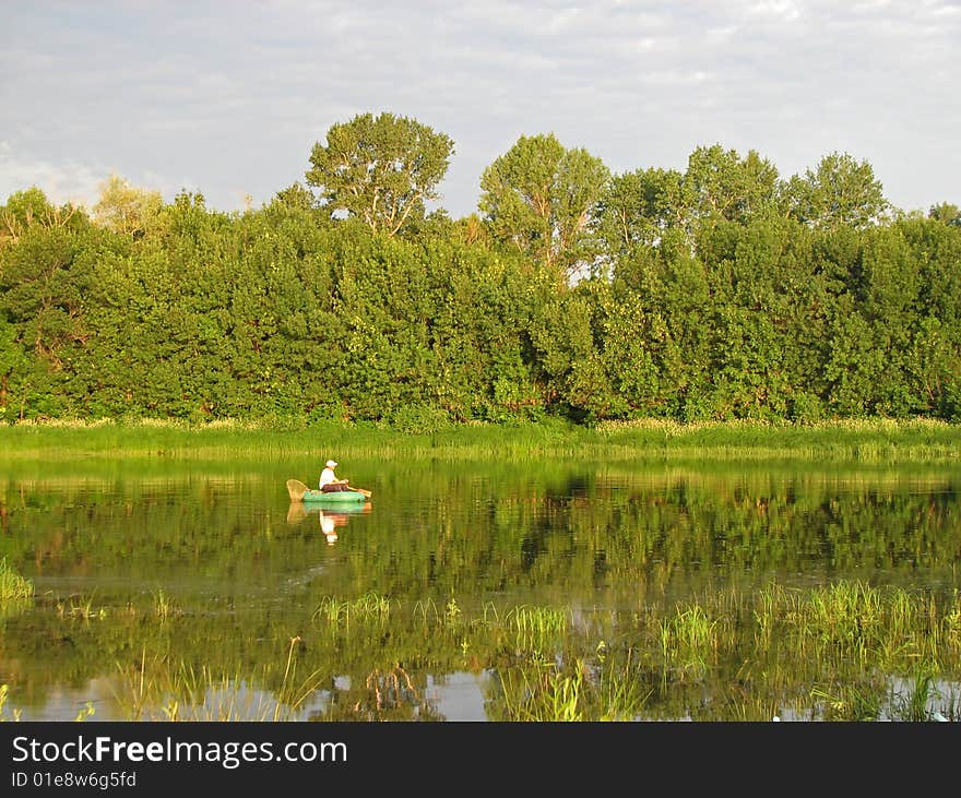 Fishing on lake from a boat at green coast