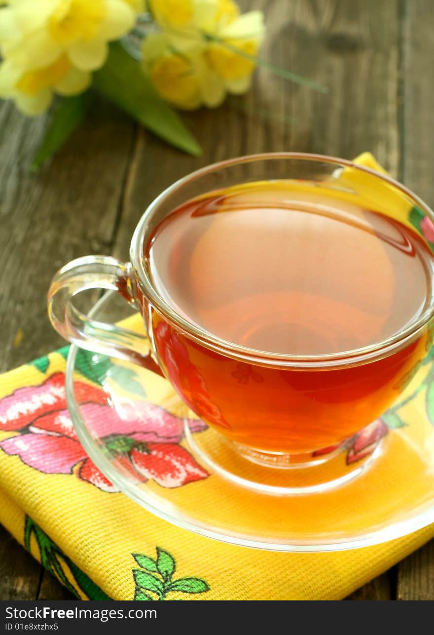 Cup of tea and flowers on old wooden background