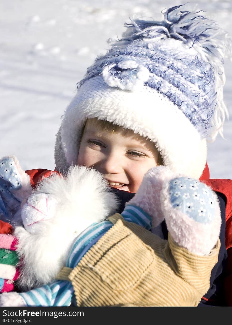 Winter day. Cute little girl on the snow.