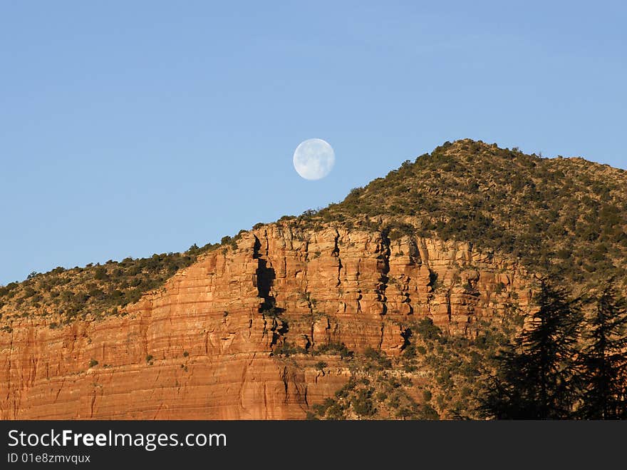 The moon setting over the red mountains of Sedona