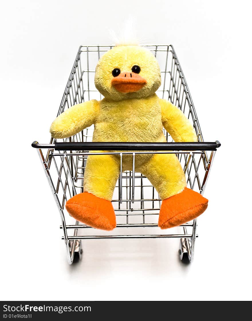 Plush toy duck sitting in a metal shopping cart. Plush toy duck sitting in a metal shopping cart.