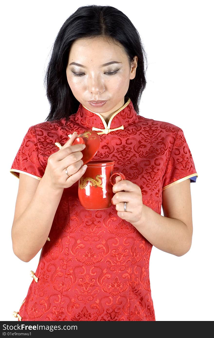 Chinese girl in traditional dress - QiPao, drinking green tea during Chinese New Year in Shanghai, China. Chinese girl in traditional dress - QiPao, drinking green tea during Chinese New Year in Shanghai, China.