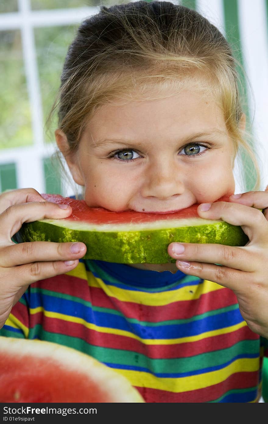 Little blond girl with a piece of watermelon in her hands. Little blond girl with a piece of watermelon in her hands