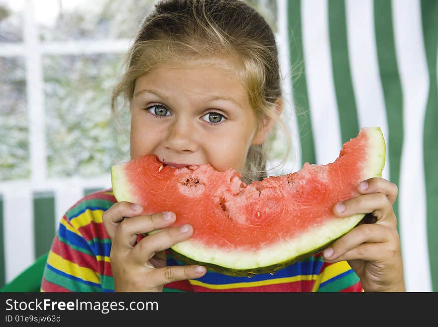 Little blond girl with a piece of watermelon in her hands. Little blond girl with a piece of watermelon in her hands