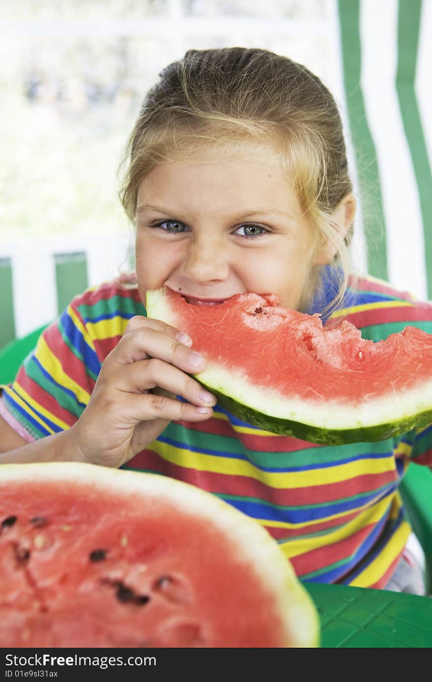 Little blond girl with a piece of watermelon in her hands. Little blond girl with a piece of watermelon in her hands