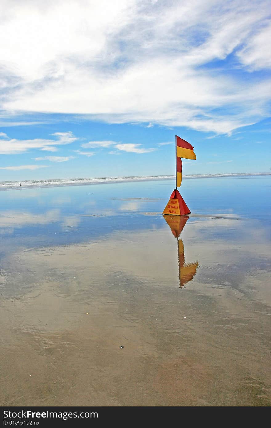 Lifeguard flag at Murawhai beach, positioned to indicate the safe area for keen surfers and swimmers. Beach situated at the west coast of New Zealand North Island region. Lifeguard flag at Murawhai beach, positioned to indicate the safe area for keen surfers and swimmers. Beach situated at the west coast of New Zealand North Island region.