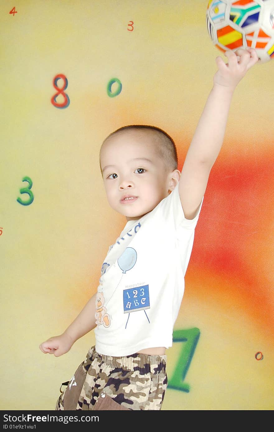 The boy`s eyes are sparkling,his left hand holding a ball and put it high up。. The boy`s eyes are sparkling,his left hand holding a ball and put it high up。