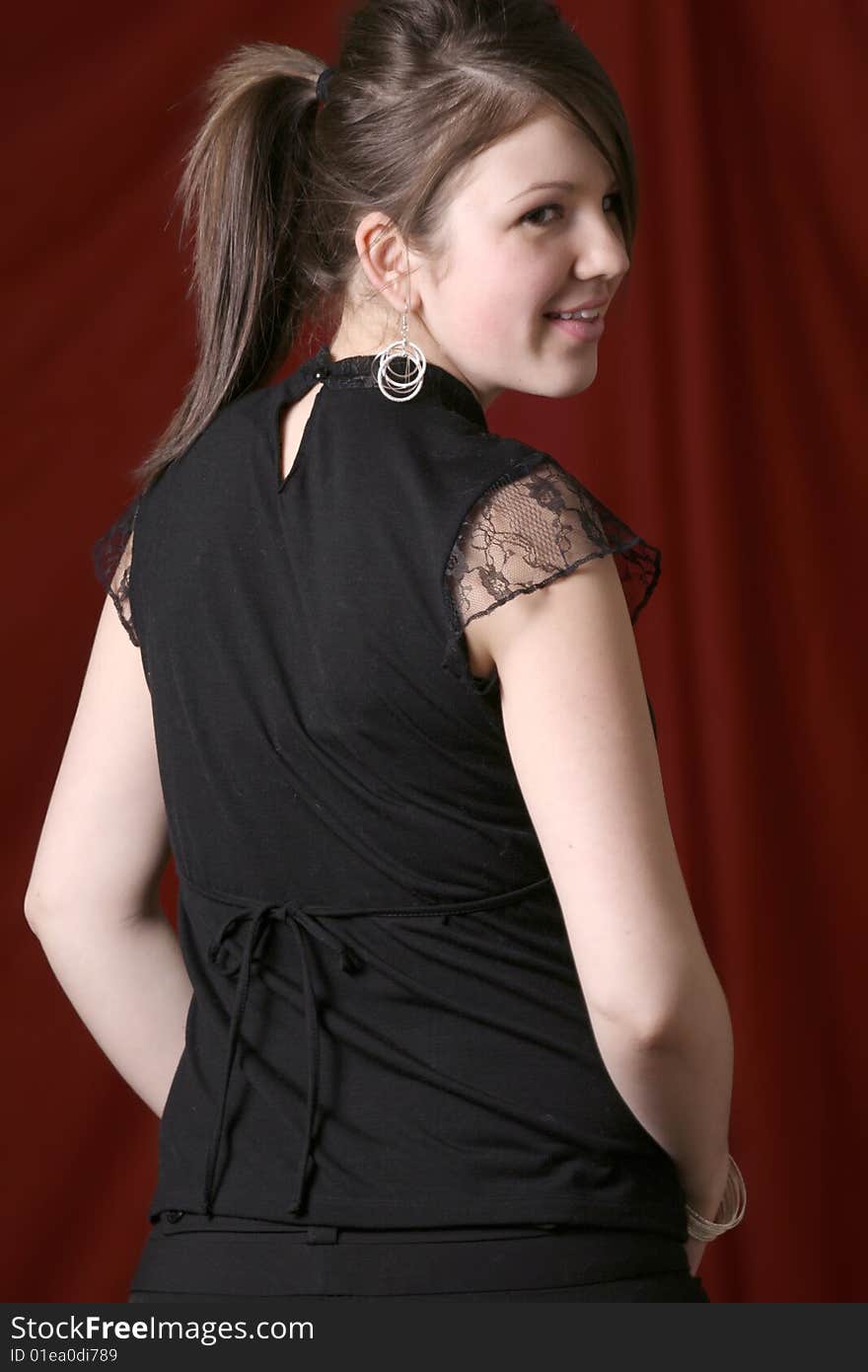 Attractive young woman looking directly into the camera over the shoulder with a slight smile on her face. Attractive young woman looking directly into the camera over the shoulder with a slight smile on her face