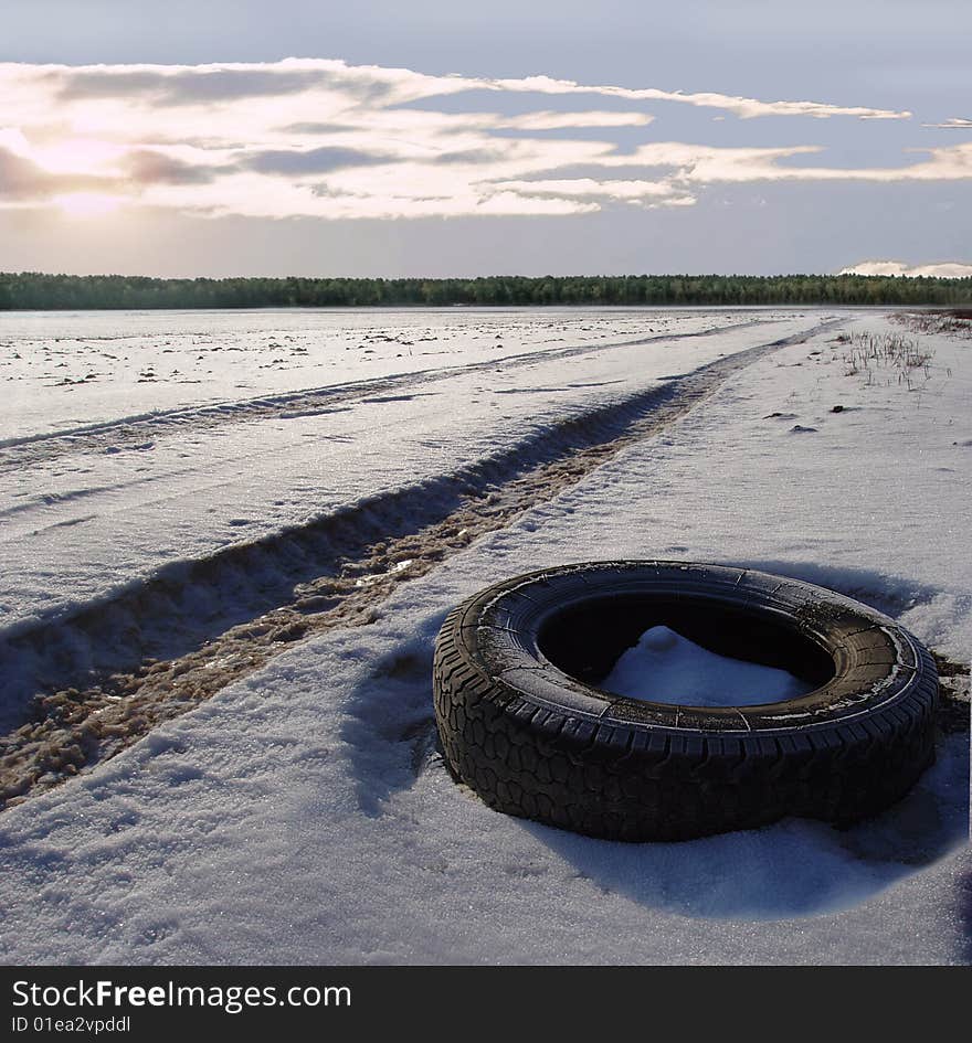 The old wheel from the car lays on road. The old wheel from the car lays on road