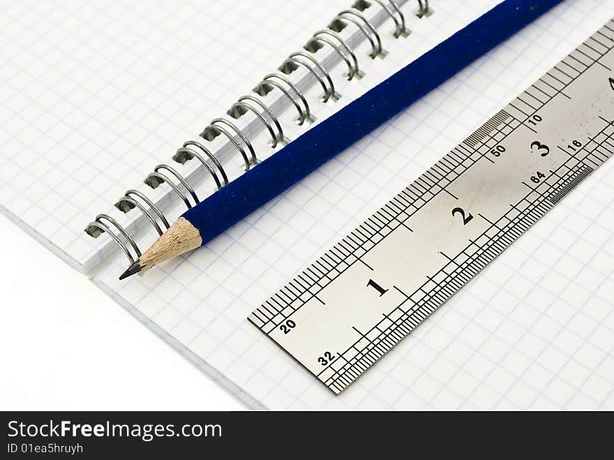 Pencil and ruler on the blank spiral notepad