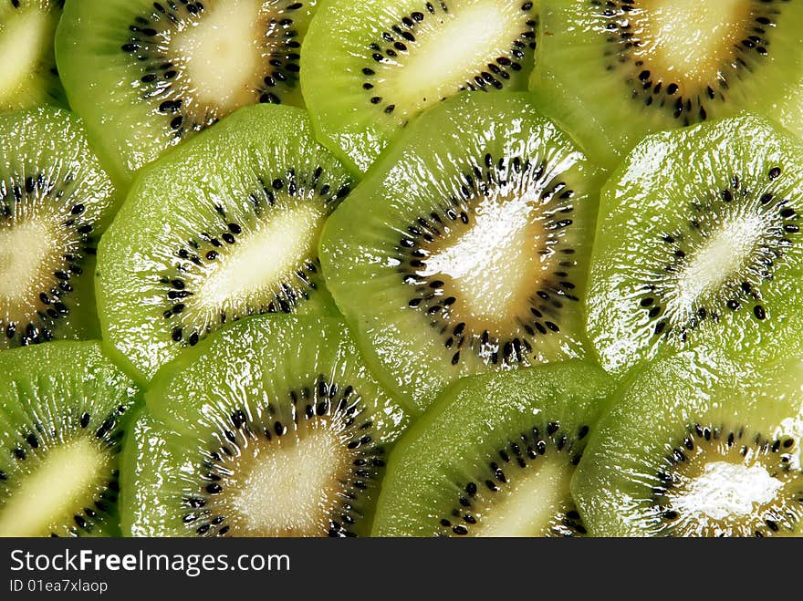 Beautiful green texture consisting of slices of kiwifruit on a white background