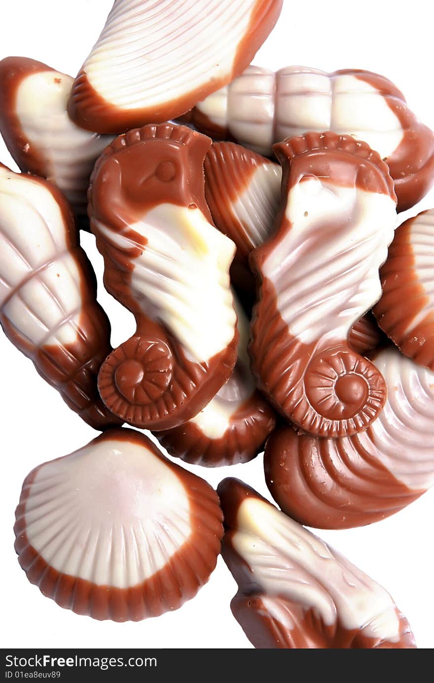 The image of sweet chocolate candies in the form of marine shellfish isolated on a white background