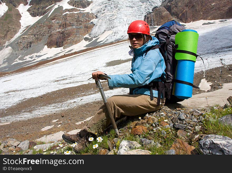 Backpacker girl with ice-axe in high Caucasus mountains