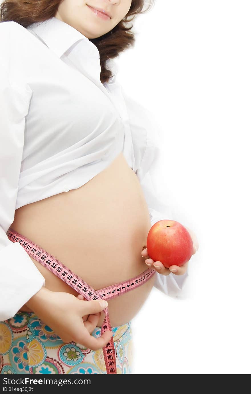 Woman holding pregnant belly with measuring tape and red apple. Woman holding pregnant belly with measuring tape and red apple