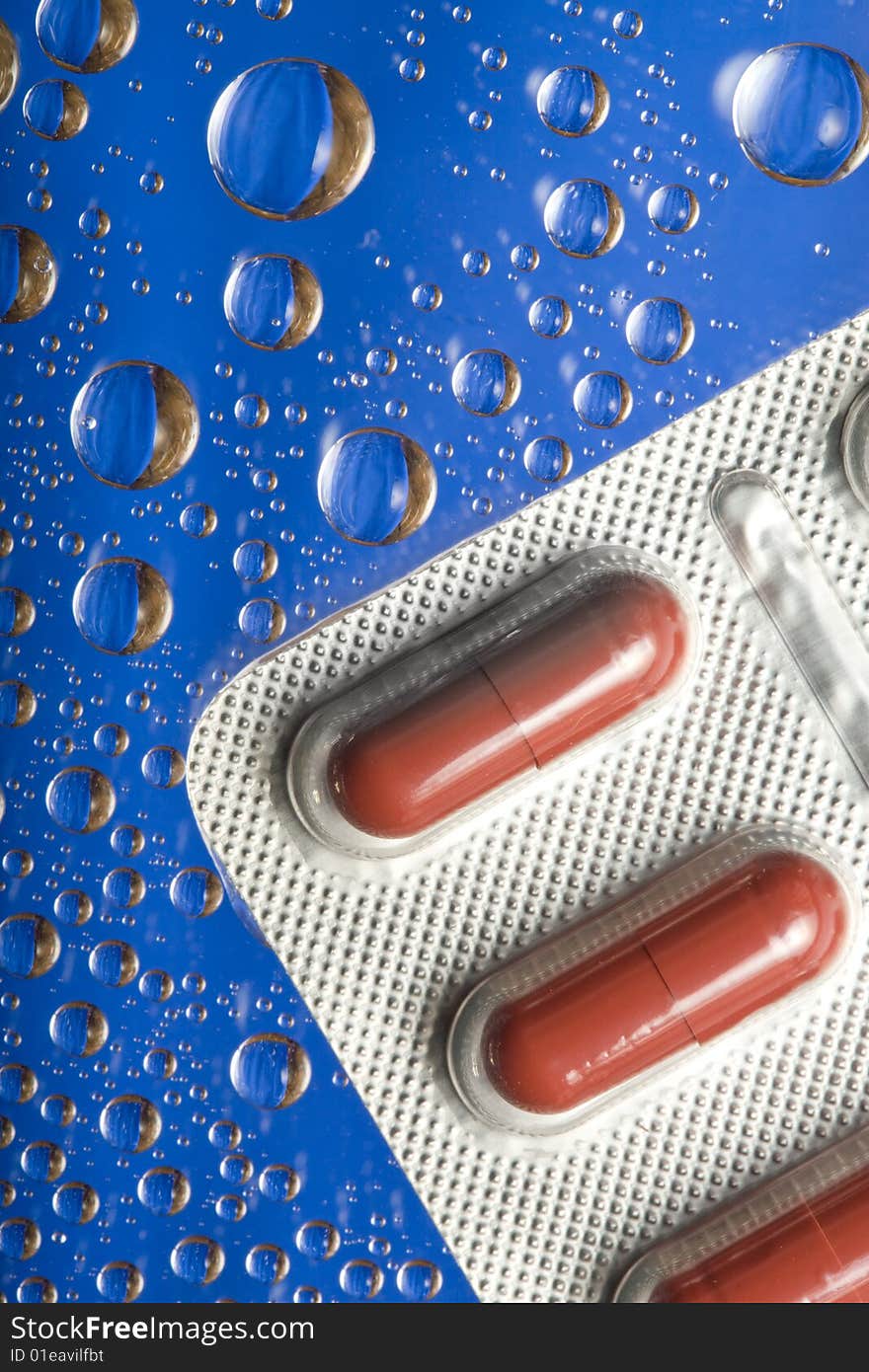 Tablets with droplets on blue background