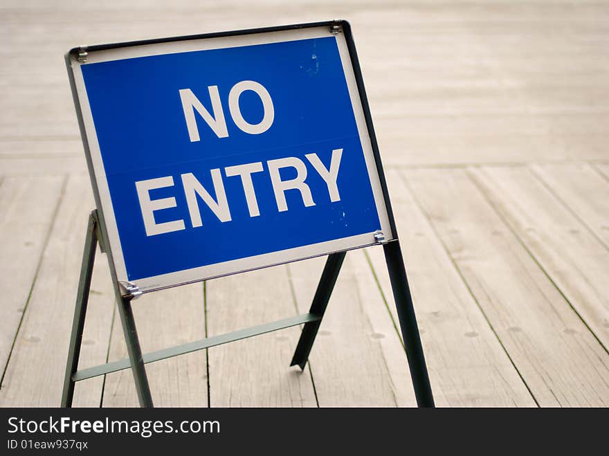 A no-entry sign board on the wooden deck. A no-entry sign board on the wooden deck.