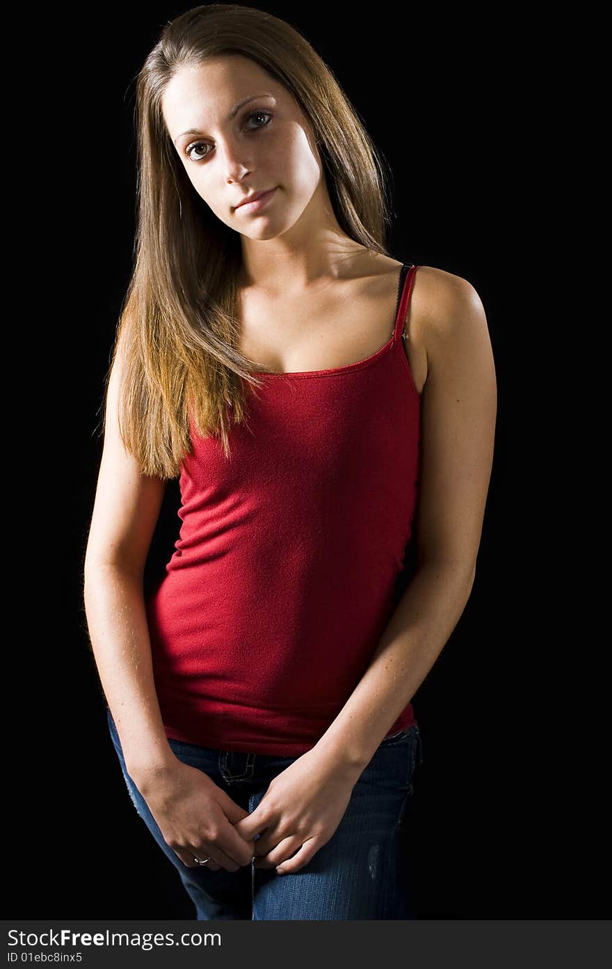 Cute model wearing a tight red tank top and jeans. Cute model wearing a tight red tank top and jeans.