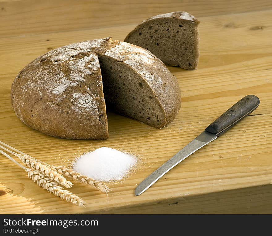 Bread and corn and knife on wooden desk