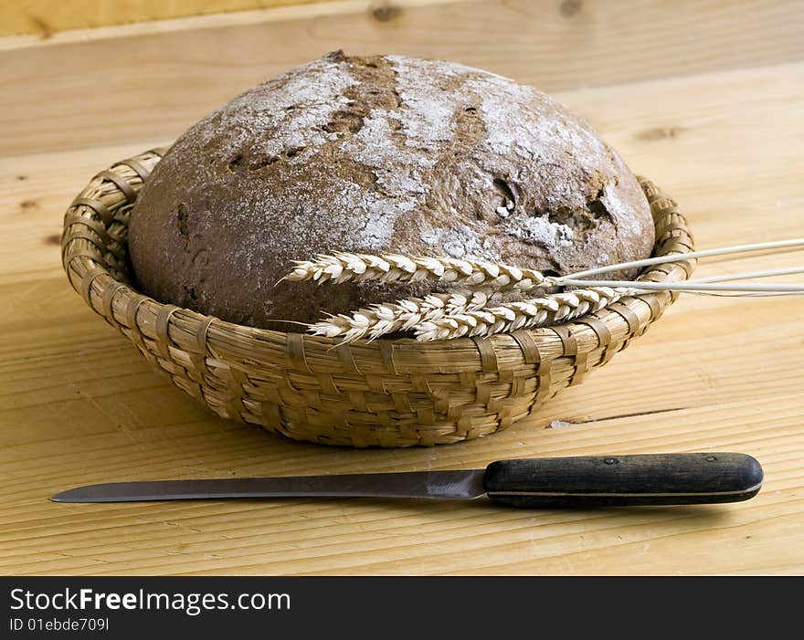 Bread and corn and knife on wooden desk