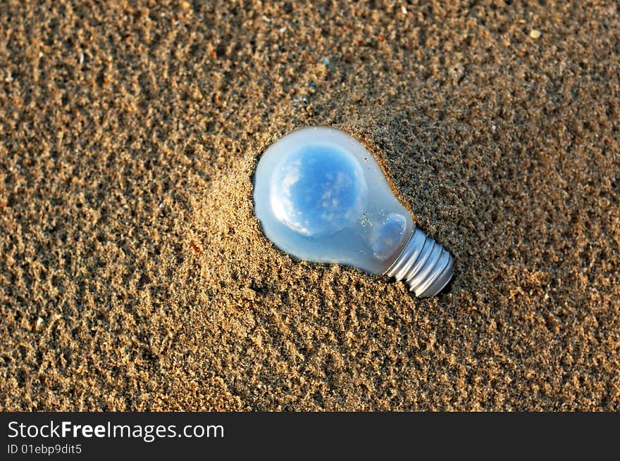 Electric lamp on the beach which contained a small world inside.