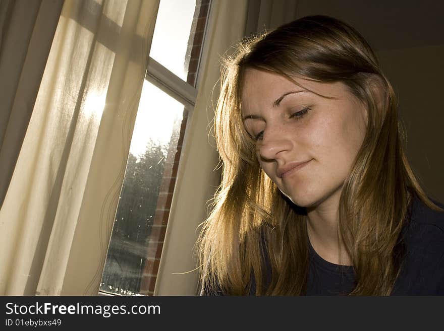 Young Woman contemplating by a sunny window