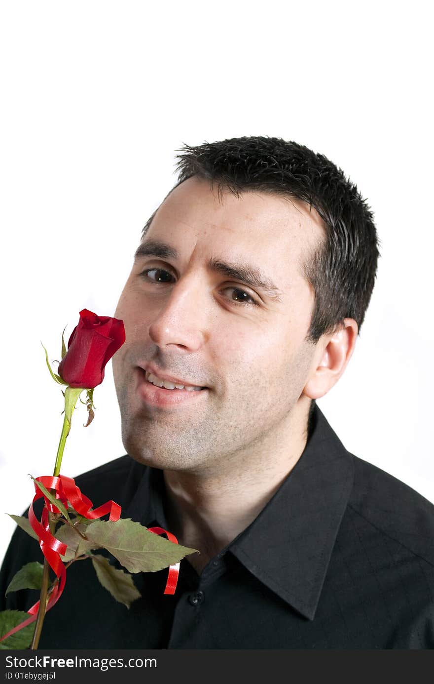 Young man, holding a red rose in front of his face, smiling. Young man, holding a red rose in front of his face, smiling