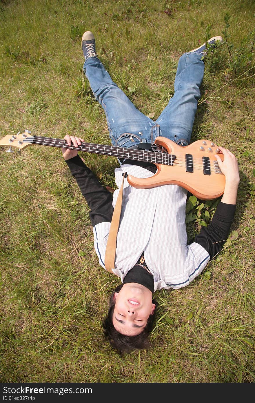 Young man  lies with guitar