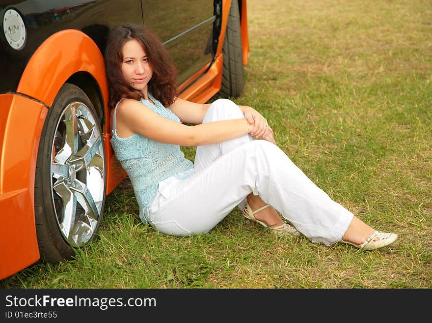 Girl Sits On Grass Near Car