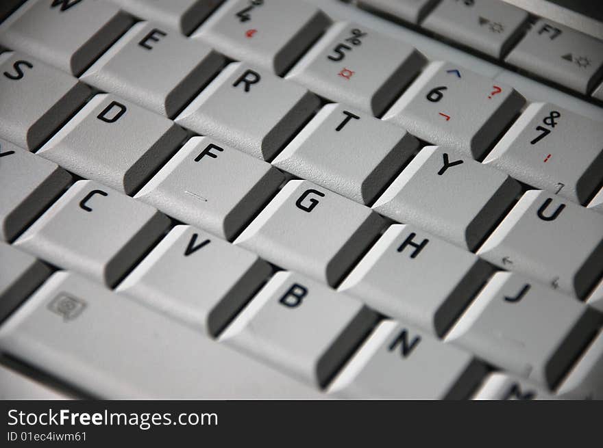 Grey laptop keyboard with red pencil