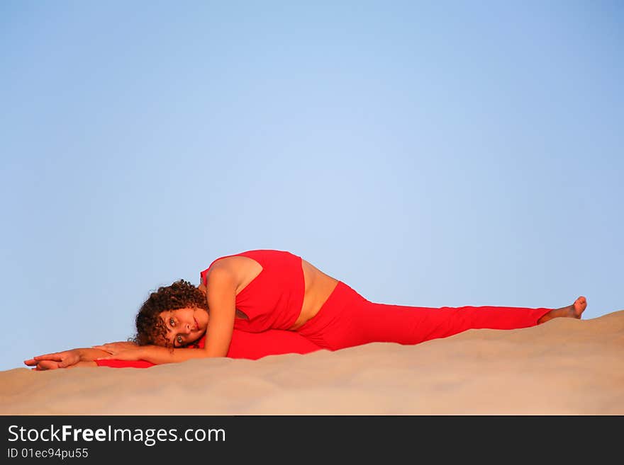 Young woman in red lies on sand. Young woman in red lies on sand