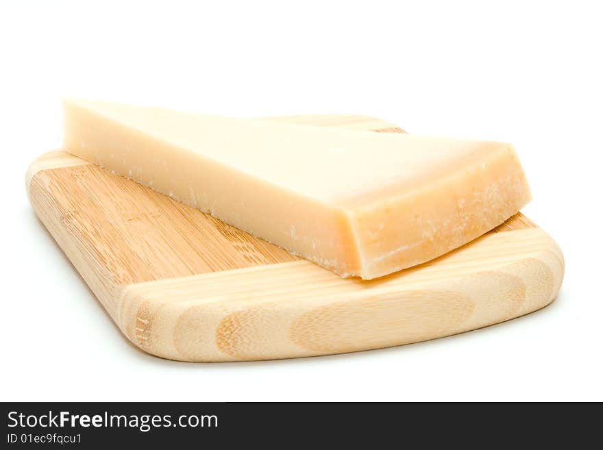 Parmesan cheese on bamboo chopping board isolated on white background.