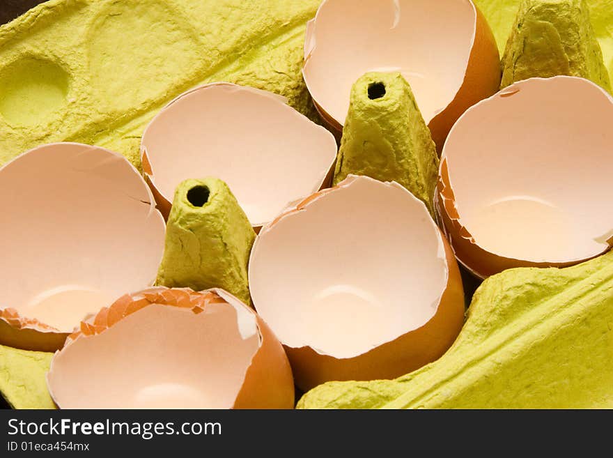 Brown eggshell in yellow cardboard egg box.