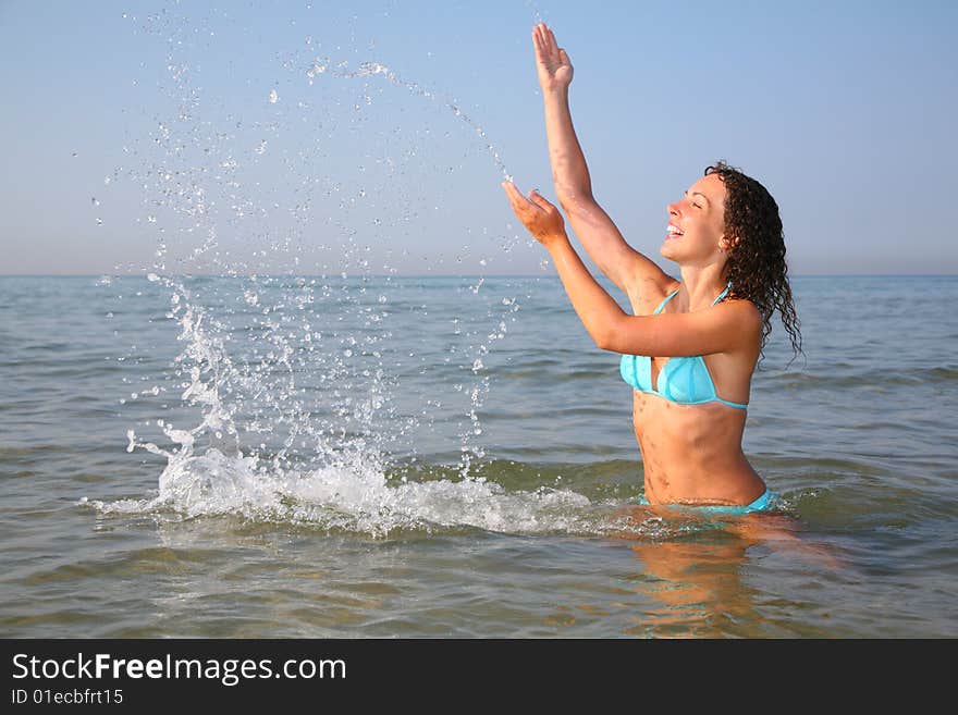 Young woman splashing in sea, summer