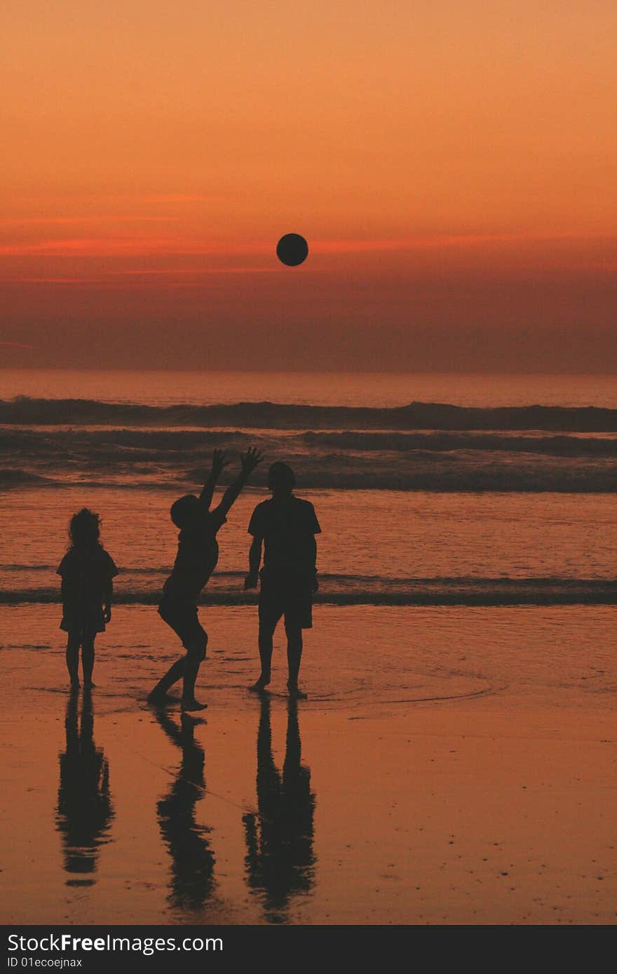 Children playing ball on the beach at sunset. Children playing ball on the beach at sunset.