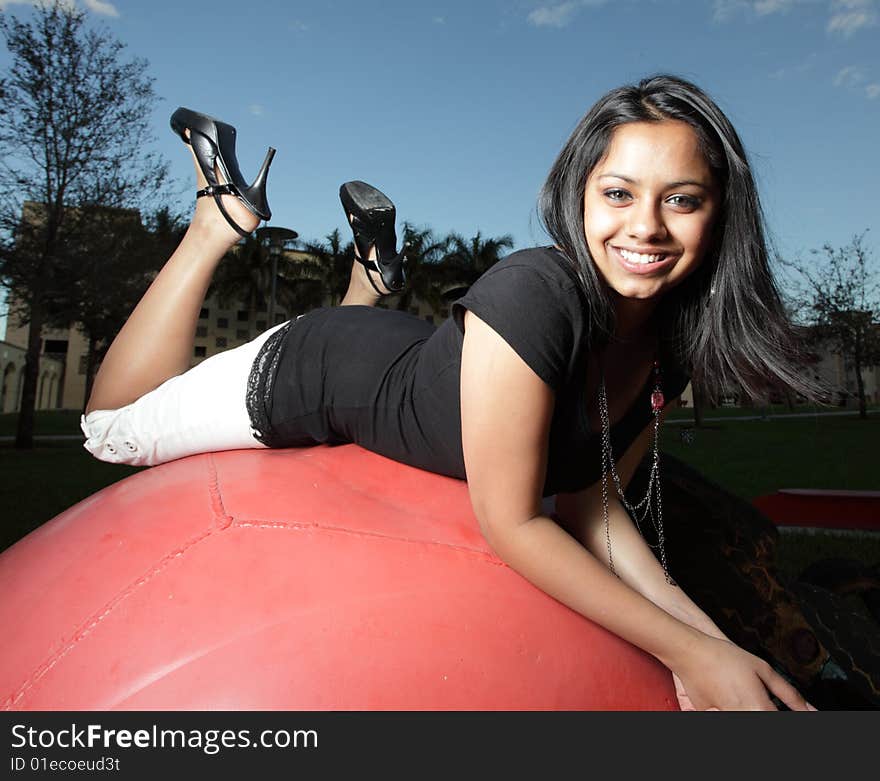 Young teenager atop of a big red ball. Young teenager atop of a big red ball