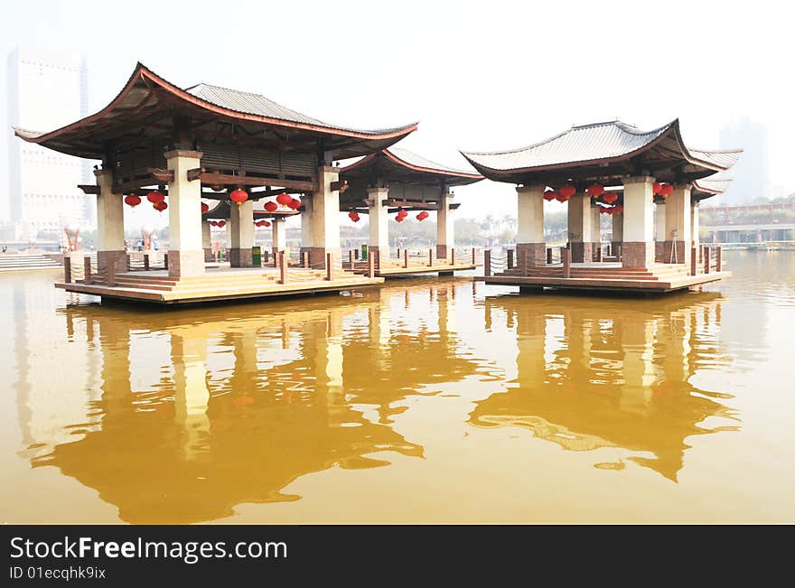 The wood and cement pavilion of Chinese traditiional style standing in the middle of a lake. The wood and cement pavilion of Chinese traditiional style standing in the middle of a lake.