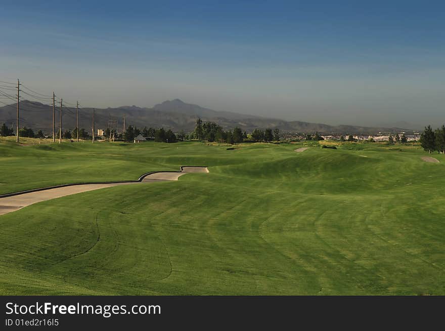 Lush green fairway grass with mountains in the background. Lush green fairway grass with mountains in the background