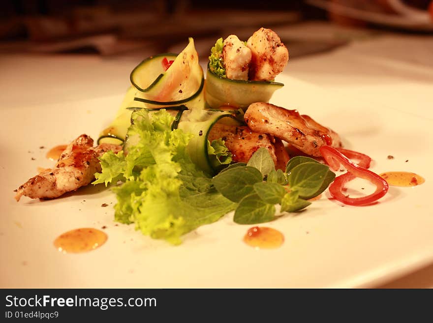 A chicken salad with lettuce, red peppers, cucumber, sprinkled with pepper and sweet chilli sauce. A chicken salad with lettuce, red peppers, cucumber, sprinkled with pepper and sweet chilli sauce