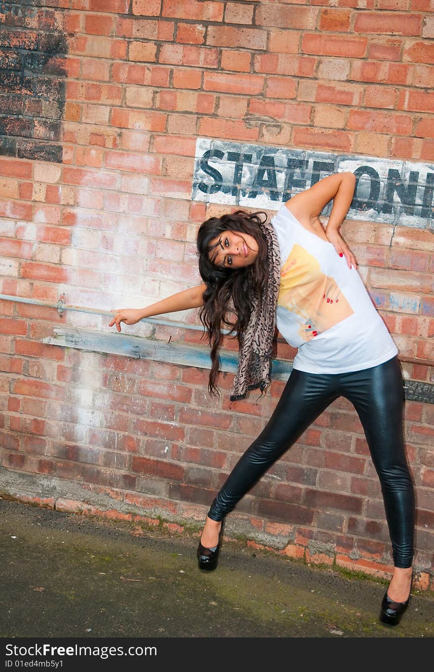 An attractive fashionable young Asian women posing in a city centre car park. An attractive fashionable young Asian women posing in a city centre car park.