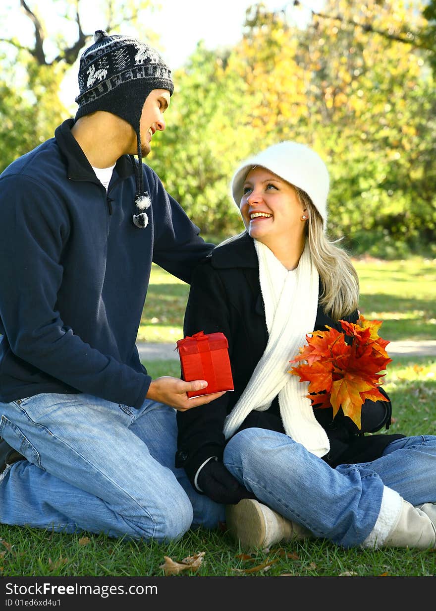 Male caucasian in urban style give a gift to his girlfriend. Male caucasian in urban style give a gift to his girlfriend