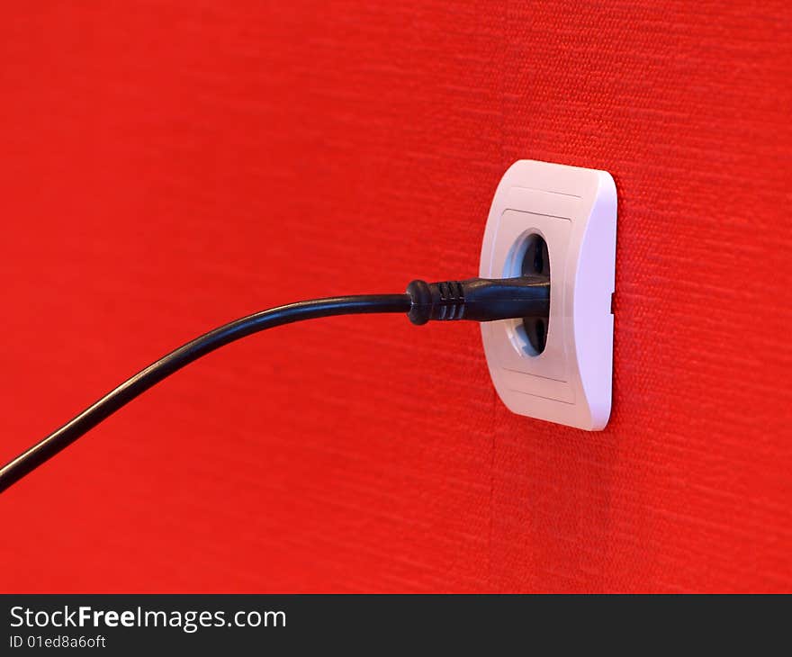 White electric socket on red wall. White electric socket on red wall