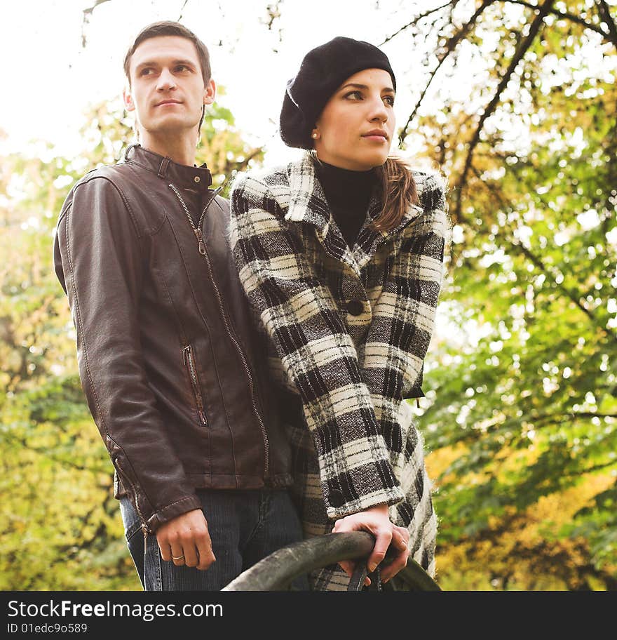 Young and beautiful husband and wife walking in an autumnal park. Young and beautiful husband and wife walking in an autumnal park